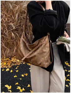 Close-up of metallic bronze tote bag with textured finish and thin shoulder straps