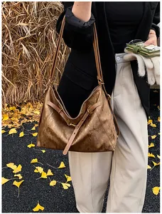 Detail of bronze large capacity tote bag with pleated texture in an autumn setting
