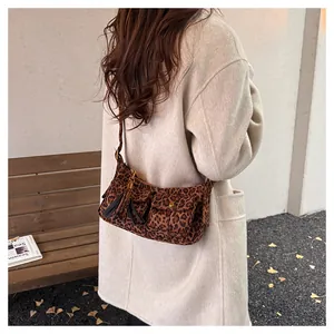 Detail of leopard print baguette bag with fringe tassel and front pockets