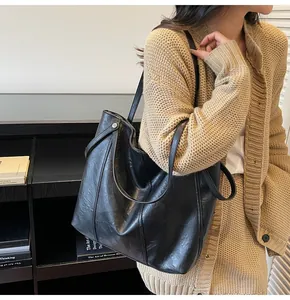 Chic black tote bag shown on a model, highlighting the large capacity and PU leather texture