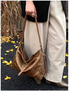Detail of hobo tote bag with bronze metallic finish and textured vintage pleats