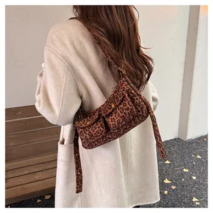 Detailed view of vintage leopard print shoulder bag with front pockets on model
