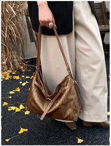 Detail of vintage textured bronze tote bag with adjustable strap and metallic finish
