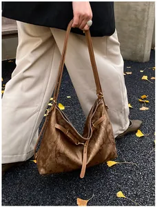 Detailed close-up of brown metallic tote bag with soft texture and adjustable straps
