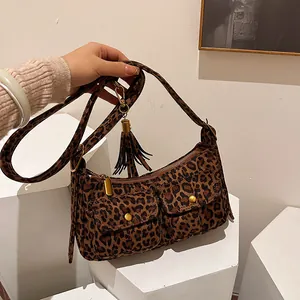 Fashionable leopard print baguette bag with dual front pockets and tassel details