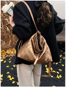 Detail of vintage metallic textured hobo bag with adjustable brown leather shoulder strap