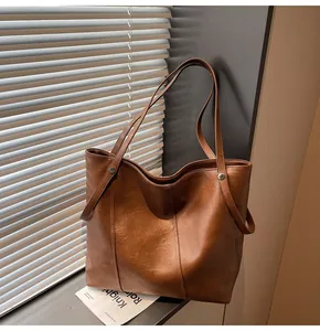 Detail of caramel tote bag with silver rivets and visible stitching for daily commuting