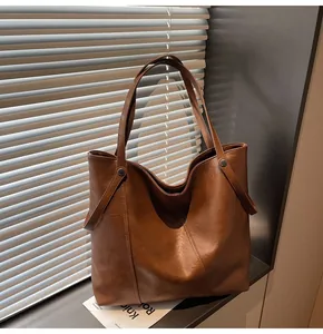 Detail showing high-quality brown PU leather texture and rivet design of the tote bag