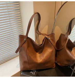 Detailed view of vintage brown tote bag with premium leather texture and rivet accents