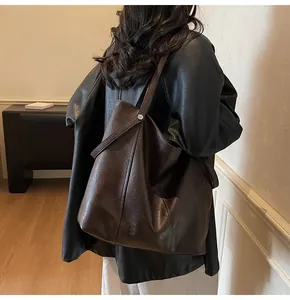 Close-up of a deep brown minimalist tote bag featuring vintage leather texture and V-seam