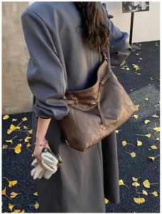 Brown vintage texture tote bag shown on model over a long coat in autumn outdoor setting