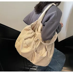 Sac cabas en velours côtelé beige avec fermeture à cordon et poches avant pour usage quotidien