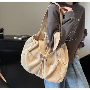 Détail du sac à bandoulière en velours côtelé avec fermeture par cordon et texture