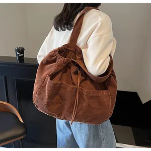 Détail du sac cabas en velours côtelé marron avec cordon et poches frontales
