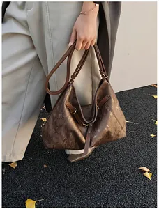 Close-up of deep brown tote bag with vintage leather texture and buckle detail