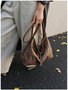 Detailed view of the dark brown leather tote bag texture with golden metal hardware