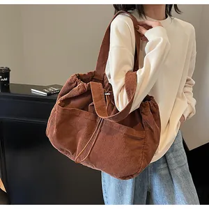 Détail d'un sac cabas en velours côtelé marron avec cordon et grandes poches avant