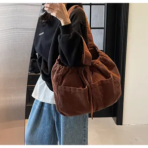 Détail du sac cabas en velours côtelé marron foncé avec grande poche et cordon de serrage