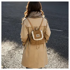 Detail of a brown corduroy backpack with white faux fur trim and drawstring closure