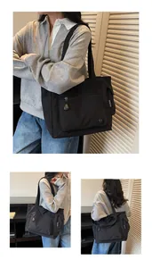 Detailed view of black nylon tote bag with functional zippers and metallic logo detail