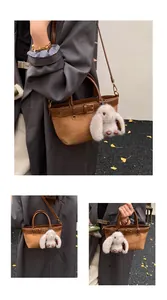 Gros plan du sac seau en daim marron avec cordon en cuir et breloque lapin en peluche
