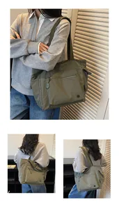 Detail view of olive green nylon tote bag showing front zipper pocket and side pockets