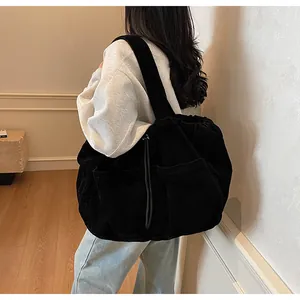 Détail du sac fourre-tout en velours côtelé noir avec cordon et grandes poches externes