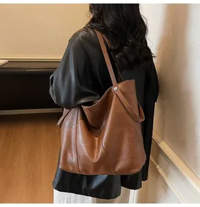 Macro view of brown leather tote bag showing soft texture and stitching details