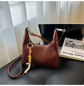 Detailed view of brown woven PU leather hobo bag with a silver buckle and wood bead charm