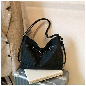 Detail of black tote bag featuring gold ring buckle and vintage textured leather finish