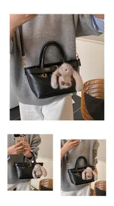 Détail d'un sac à main noir brillant avec boucle décorative et charm de lapin en peluche gris