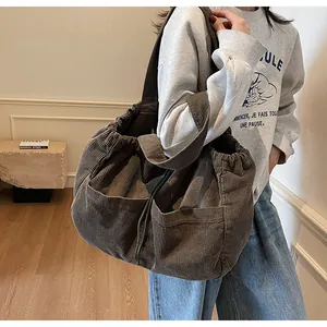 Détail du sac cabas en velours côtelé marron avec cordon de serrage et poches latérales