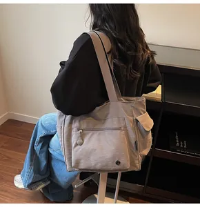 Detailed side view of khaki nylon tote bag with functional pockets and wide strap