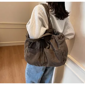 Détails du sac cabas en velours côtelé marron avec cordon et poches externes