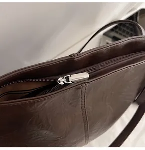 Detail of premium brown leather tote with silver zipper and textured surface