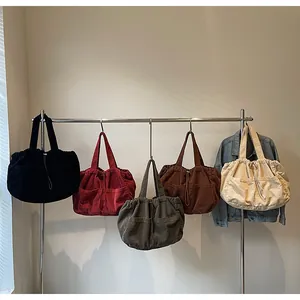 Détail de sacs cabas en velours côtelé en cinq couleurs avec cordon et grandes poches