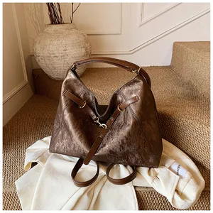 Close-up of deep brown tote featuring brushed texture and premium gold hardware details