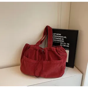 Détail du sac cabas en velours côtelé bordeaux avec rayures et cordon de serrage
