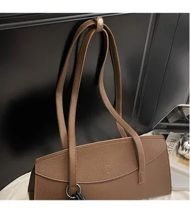 Detail of a brown lychee pattern leather tote bag with durable slim shoulder straps