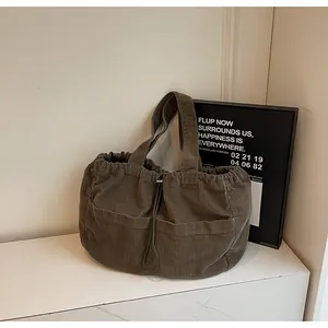 Détail du sac cabas en velours côtelé marron avec cordon de serrage et poches avant