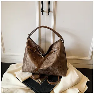 Macro detail of bronze hobo bag featuring textured metallic leather and silver hook buckle