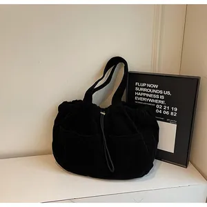 Détail du cabas en velours côtelé noir montrant les poches avant et la texture côtelée