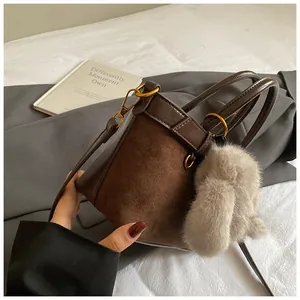 Détail du sac seau vintage mat marron foncé avec breloque en fourrure de lapin