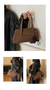 Close-up of brown pebbled leather tote bag with stylish mini pouch and black chain detail