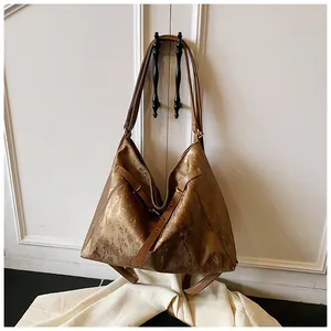 Detail of bronze textured large tote bag showing metallic finish and decorative buckles
