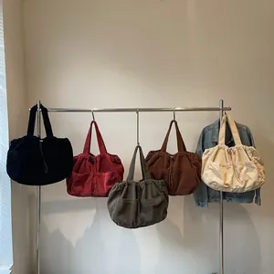 Sacs cabas en velours côtelé en cinq couleurs avec cordon de serrage sur support