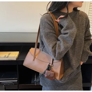 Detail of brown lychee leather tote bag with matching mini coin purse on a shoulder strap