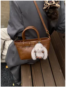 Sac cabas vintage marron mat avec boucle dorée et breloque lapin en peluche blanche