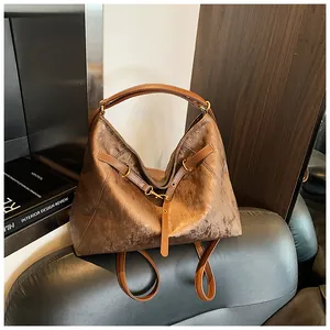 Detailed macro view of deep brown hobo bag with metallic silk texture and retro gold rivets