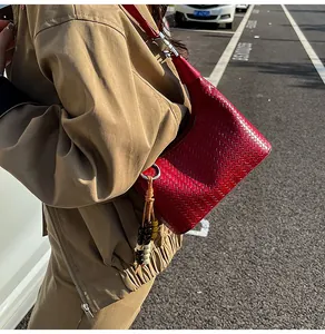 Detailed macro view of red woven hobo bag with colorful wooden bead tassel charm